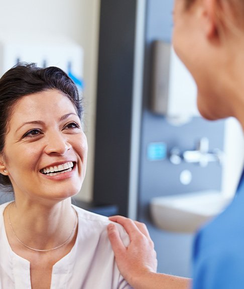 Patient in Lakewood talking to dentist about affordable dentures