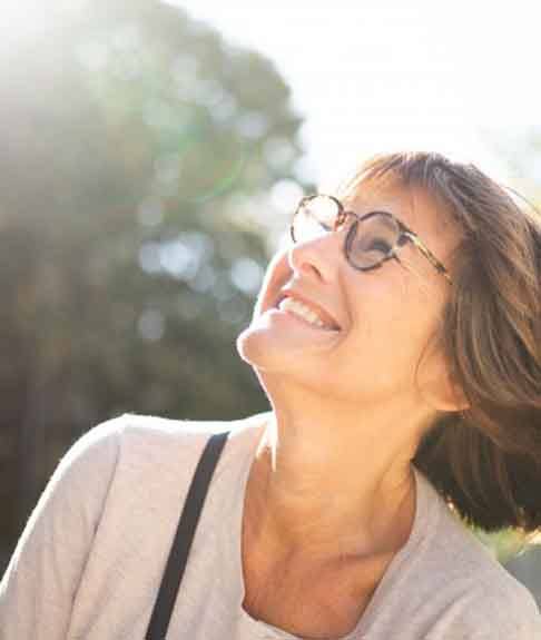 an older woman walking outside and smiling