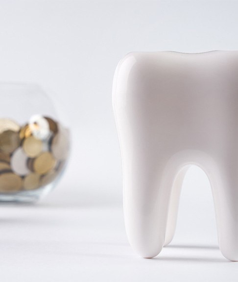 Tooth next to a pile of coins