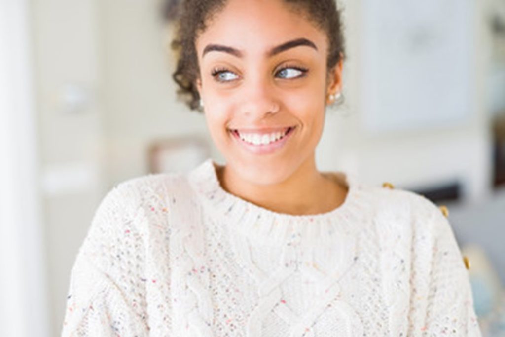 person smiling after veneer replacement