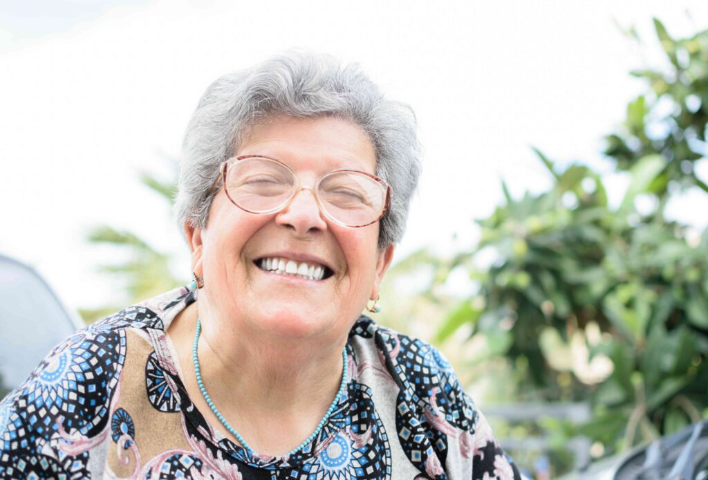 Woman smiling outside with dentures